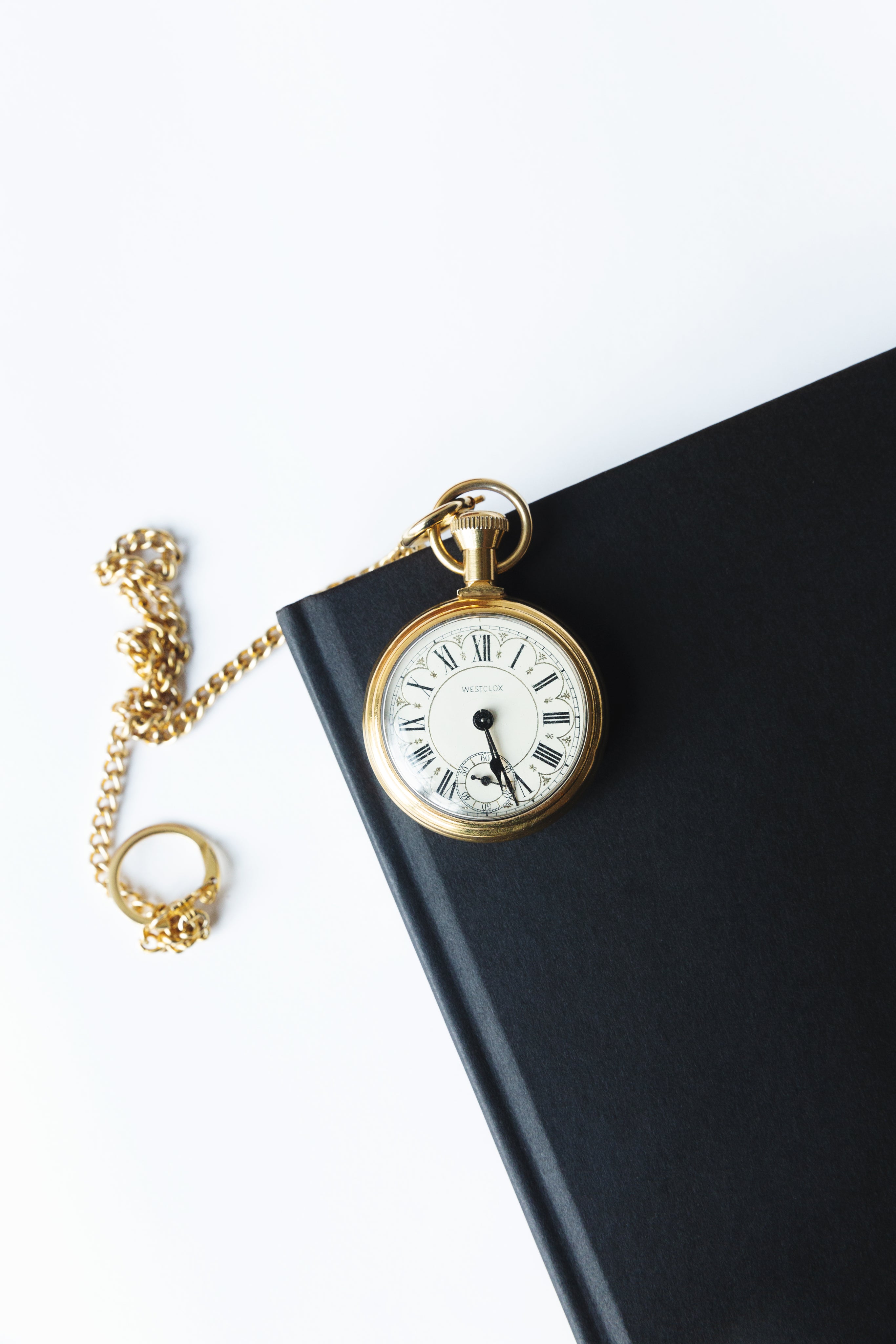 gold-pocket-watch-on-a-black-notebook